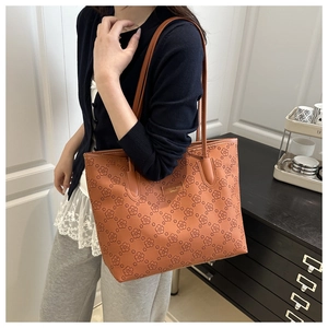 Detail of caramel tote bag with floral embossing and slim shoulder straps