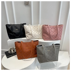 Detailed arrangement of five floral embossed tote bags in diverse colors on a white pedestal