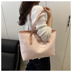 Detailed view of pink textured fabric tote with white butterfly embroidery and leather straps
