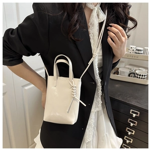 Vue détaillée d'un mini sac blanc en cuir PU avec bandoulière nouée sur mannequin