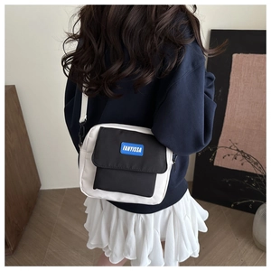 Close-up of the FANYISSA contrast flap and logo label on a casual crossbody bag