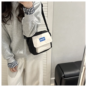 Detail of the black and white crossbody bag with FANYISSA label and adjustable strap