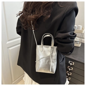 Rear view of silver mini bucket bag with rope knot detail on a black blazer outfit