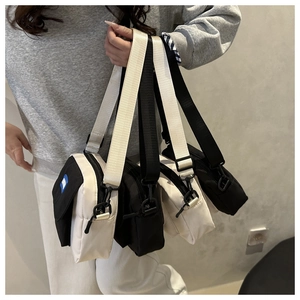 Group display of compact nylon crossbody bags in black and beige with adjustable straps
