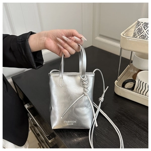 Detail of silver metallic leather mini bag with Fashion Bags print and knotted shoulder strap