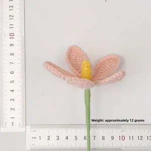 Detail view of handmade pink crochet flower with measuring rulers showing 8-9cm diameter size