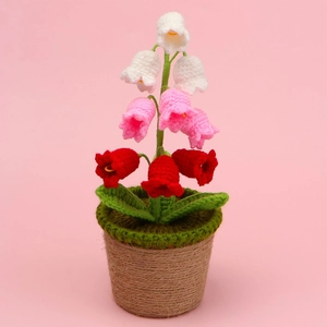 Detailed close-up of handmade crochet lily of the valley potted plant with colorful flowers