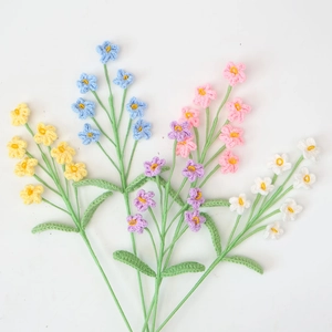 Macro detail of hand-knitted forget-me-not flowers showing fine crochet texture and multi-colors