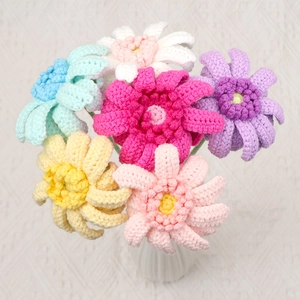 Handgefertigter gehäkelter Gerbera-Blumenstrauß in weißer Vase mit buntem Garn