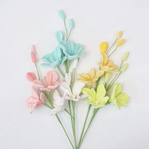 Macro detail of handmade crochet dendrobium flowers in pastel pink, blue and yellow yarn