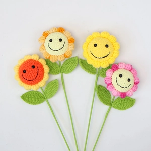 Gros plan de quatre tournesols au crochet faits main avec de jolis visages souriants