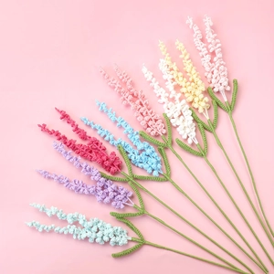 Handmade crochet lavender bouquet with colorful knitted flowers on pink background