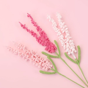 Handmade knitted lavender bouquet in shades of pink with soft green woven leaves