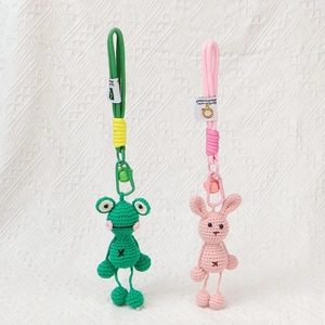 Detail von handgehäkelten Tieranhängern mit einem grünen Frosch und rosa Hasen