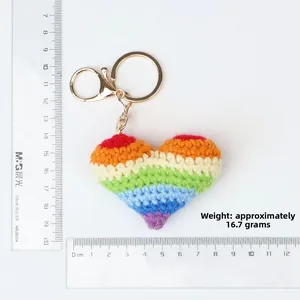 Detailed macro view of rainbow crochet heart keychain with measurement ruler scale