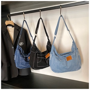 Tre borse a tracolla in denim nei colori blu, nero e azzurro in fila