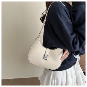 Model trägt eine minimalistische cremefarbene Hobo-Bag mit silberner Schnalle