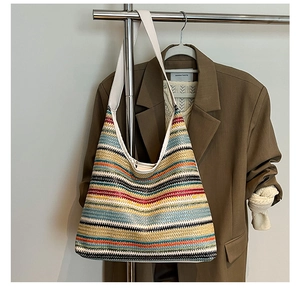 Détail de la texture tricotée d'un grand sac hobo à rayures arc-en-ciel colorées