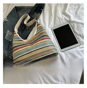 Détail macro du sac hobo tissé à rayures arc-en-ciel avec bandoulière en cuir beige