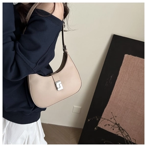 Detailansicht der beigen Hobo-Tasche aus Leder mit silberner Schnalle und Halbmond-Design