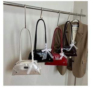 Detail of four retro underarm bags in silver, black, red and brown with lace bows