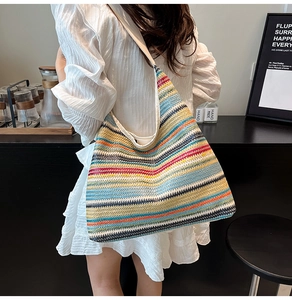 Détail d'un sac cabas tissé à rayures colorées avec texture paille et bandoulière claire