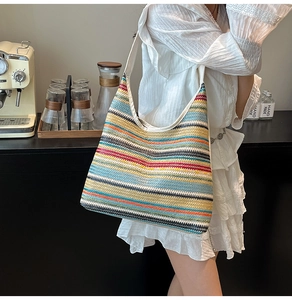 Close-up of colorful striped woven tote bag with a white shoulder strap for summer style