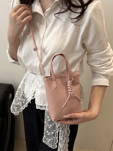 Pink mini leather tote bag with woven handle knot and adjustable shoulder strap