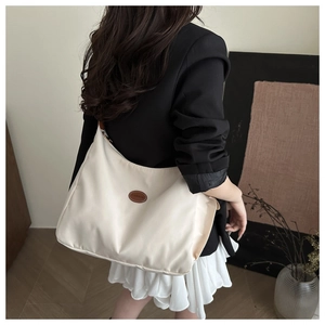 Detailed back view of a cream nylon tote bag showing its large capacity and shoulder fit