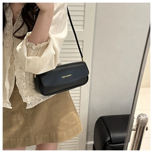 Mirror selfie showing a black leather baguette bag worn as a shoulder underarm bag