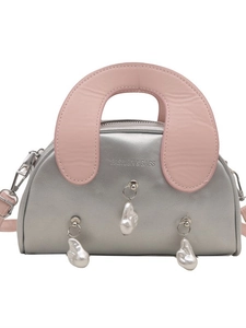 Silver metallic shell handbag with pink handles and pearl charms on white background