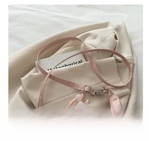 Detailaufnahme des verstellbaren rosa Schultergurts und floraler Stickerei der Tasche