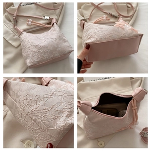 Detailansicht der rosa Spitzen-Handtasche mit Innenraum und Perlenquasten-Anhänger