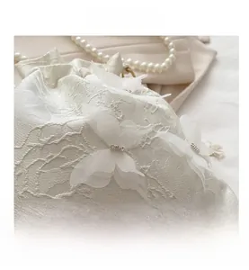 Dettaglio della borsa a secchiello bianca con farfalle in organza 3D e strass