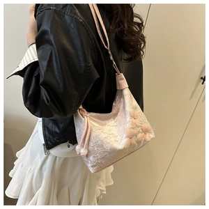 Detail der rosa Spitzenschultertasche mit 3D-Schleifen und dekorativen Perlenanhängern