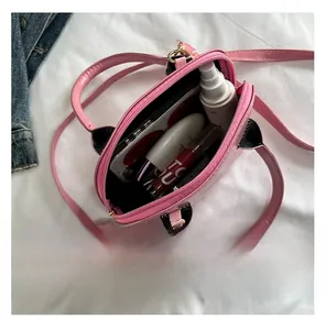 Pink patent shell bag interior showing storage space for phone and cosmetics