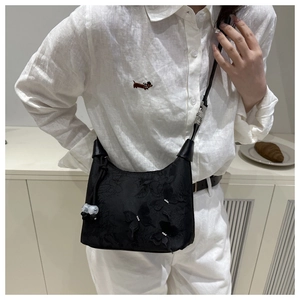 Détails de broderies papillons sur sac en nylon noir avec pendentif en perles