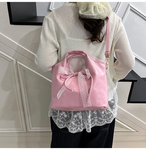 Bolso de cuero PU rosa con lazo de encaje blanco usado por una modelo
