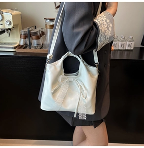 Detalle del bolso blanco crema con lazo grande y adornos de encaje delicados