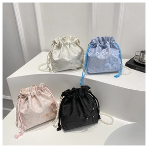 Detail view of jacquard bucket bags with 3D butterfly appliques and pearl chain straps