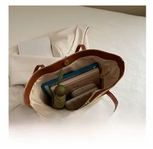 Detail view of woven tote bag interior capacity holding a tablet and daily essentials