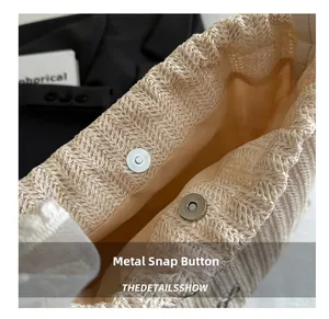 Nahaufnahme des Metall-Magnetverschlusses an der beigen Stroh-Eimertasche mit Stofffutter
