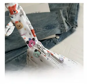 Close-up of smooth silver metal zipper on white cartoon bear print shoulder bag