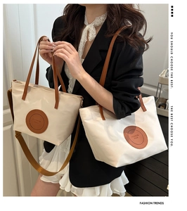 Detail showing high-quality nylon tote bags with round brown leather logo patches and straps