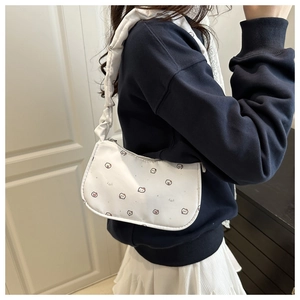 Detail of ruched shoulder strap and cute cartoon animal print on off-white underarm bag