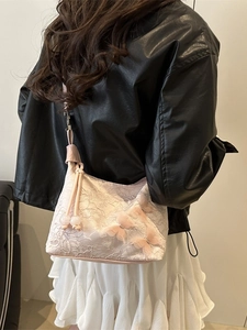 Sac bandoulière en dentelle rose avec papillons 3D porté par un mannequin au style décontracté