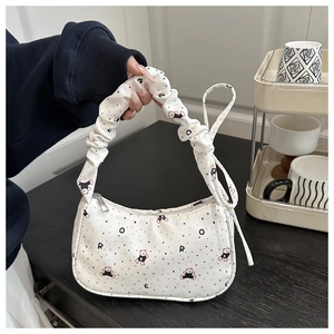 Detail of white printed hobo bag featuring bear patterns and ruched scrunchie handle