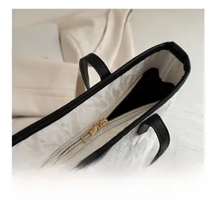 Close-up of smooth gold zipper closure on minimalist marbled textured tote bag
