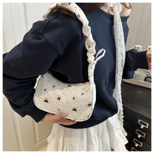 Detail of white canvas underarm bag with bear print and ruffled drawstring shoulder strap