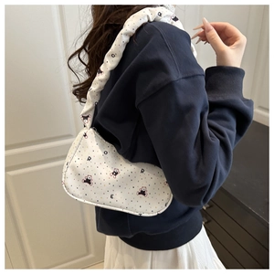 Detail of white canvas shoulder bag with cartoon bear print and ruched strap